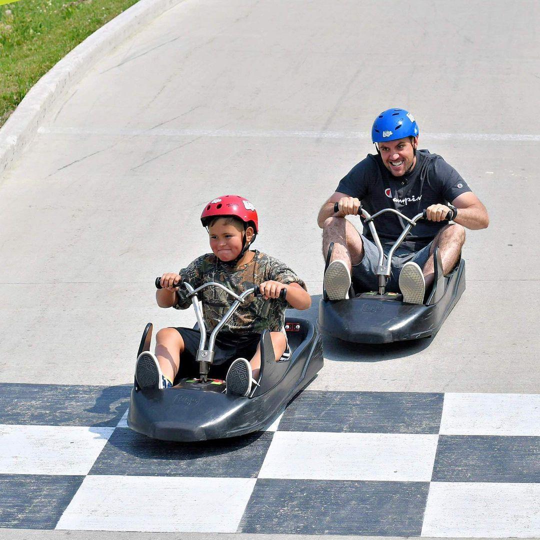 A father chases his son down the tracks at Downhill Karting Calgary.
