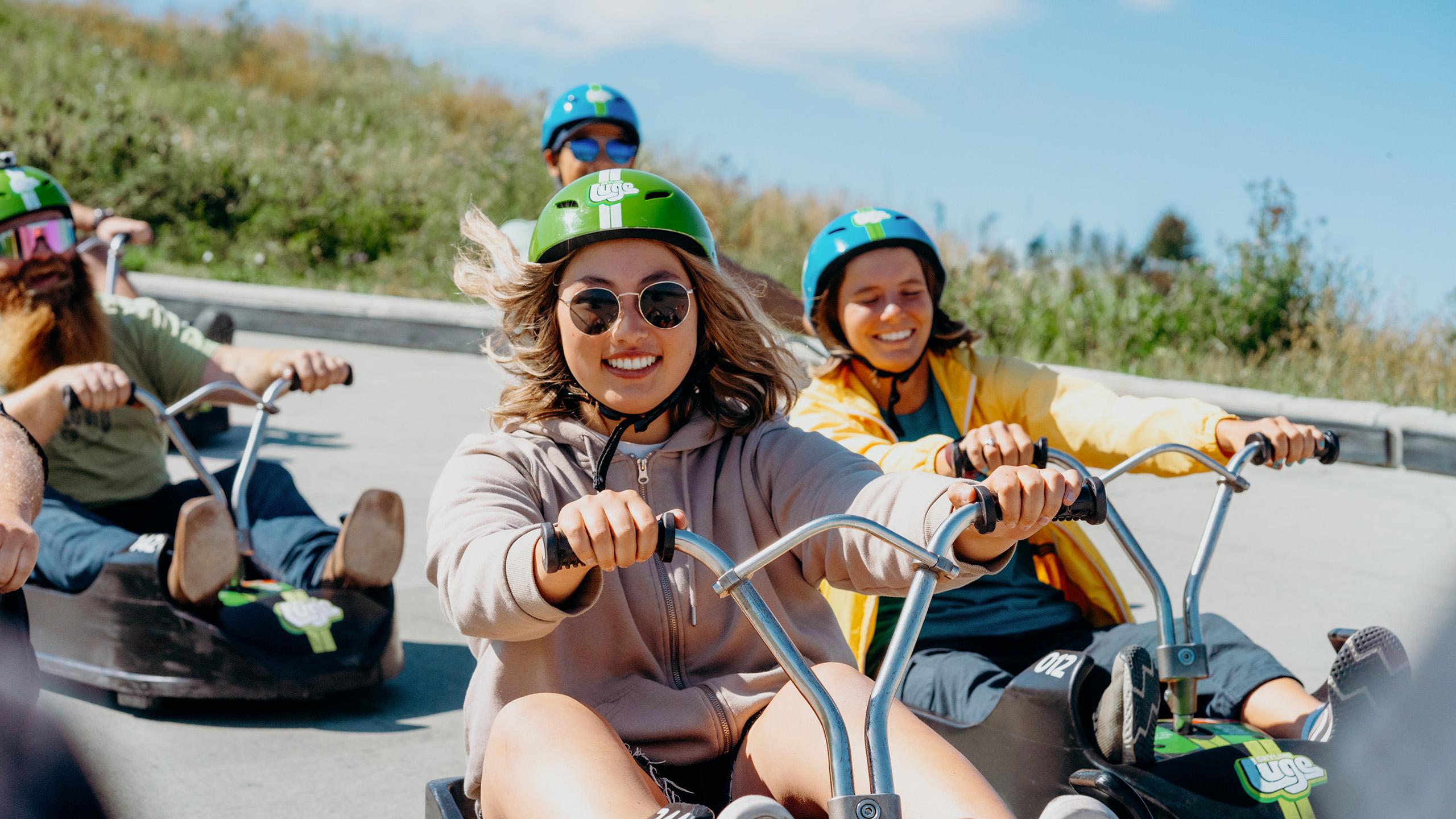 A lady descends the Downhill Karting Calgary tracks with friends following closely.