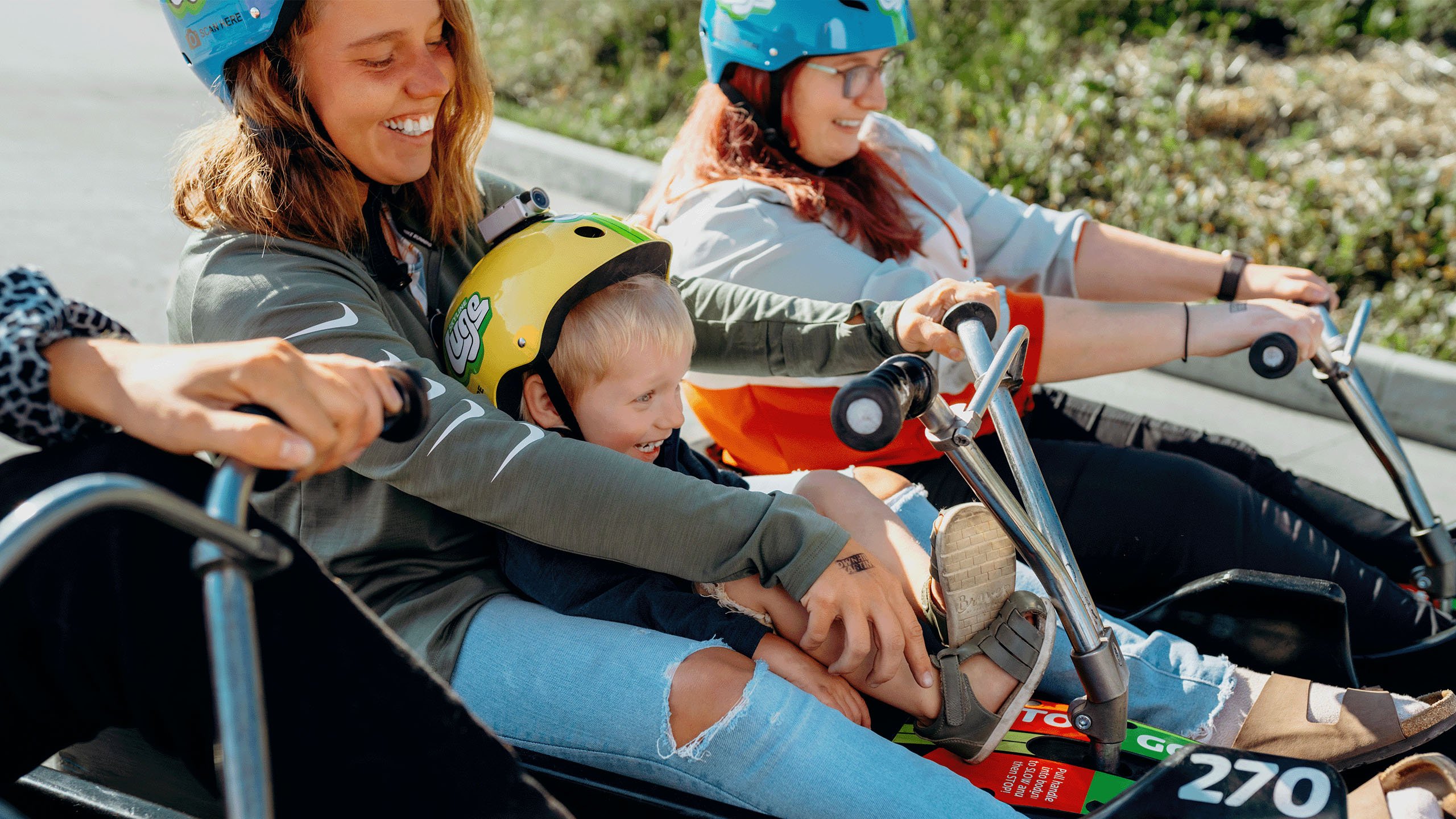 A mother and child smile as they prepare to ride the tracks at Downhill Karting Calgary.