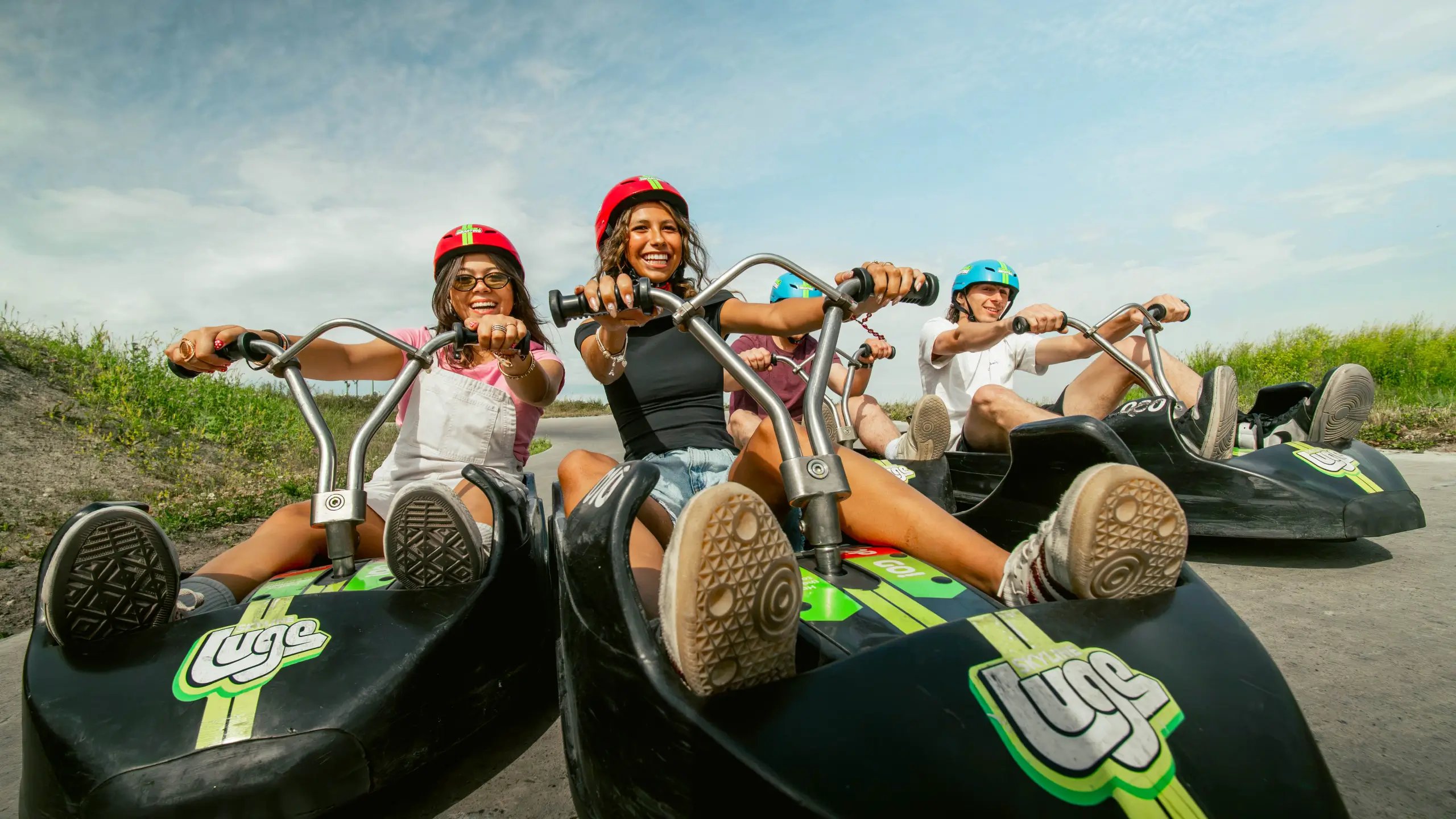 A group of friends smile as they ride together at Downhill Karting Calgary.