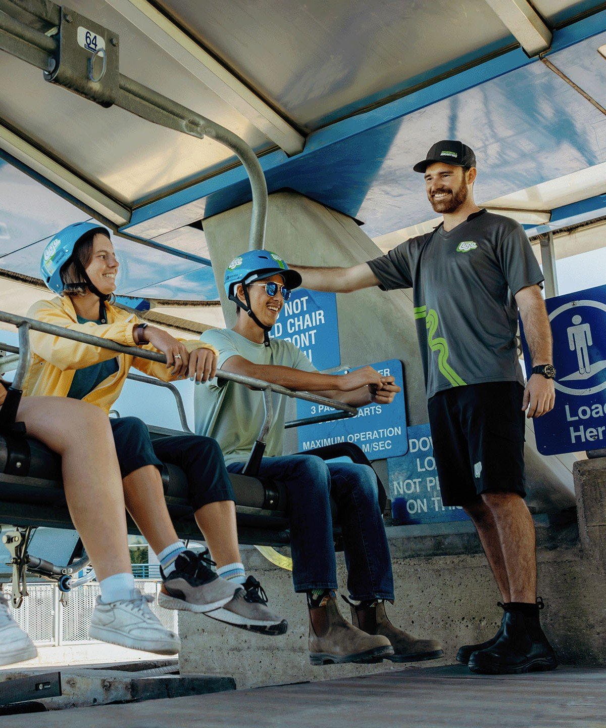 Three friends are seated on the chairlift ready to head to the top of the tracks at Downhill Karting Calgary.