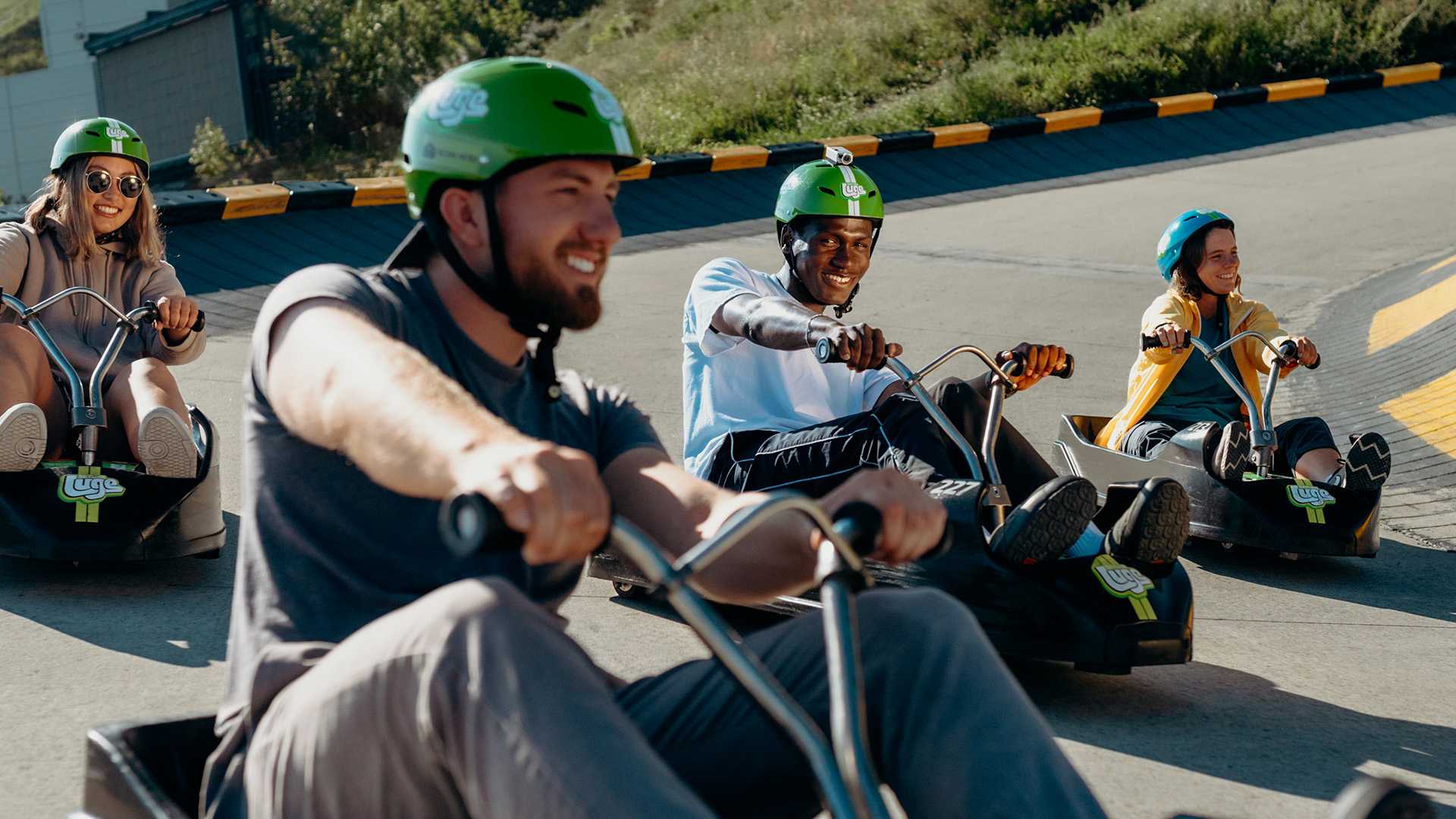 A group of friends race around a corner together at Downhill Karting Calgary.