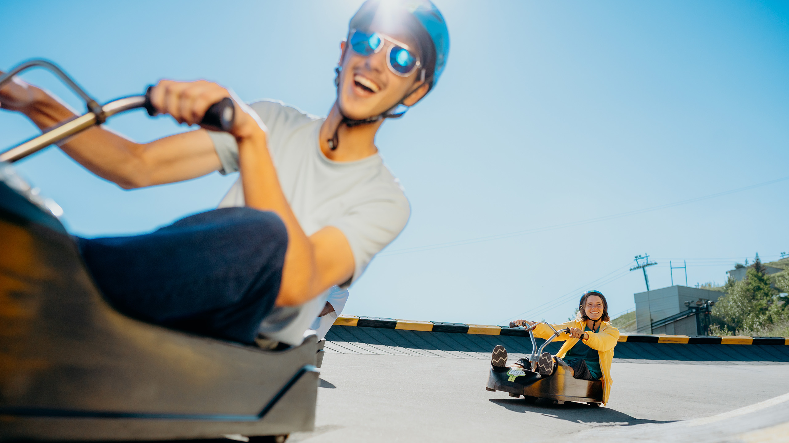 A man smiles as he races down the tracks with a woman following him closely.