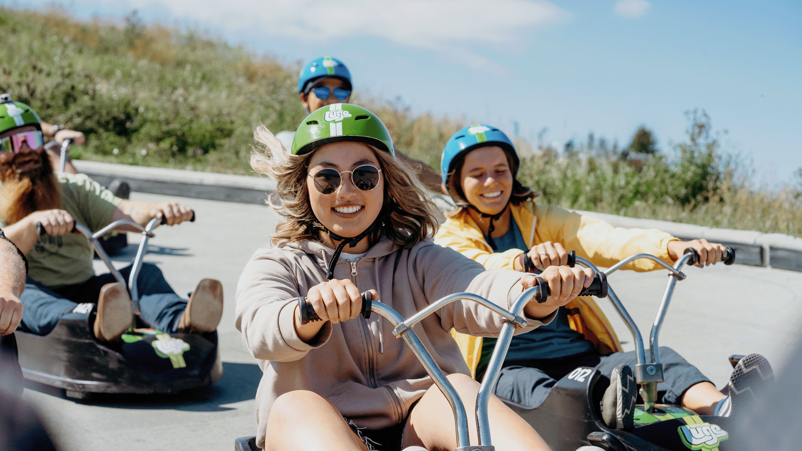 A lady grins as she heads down the tracks at Downhill Karting Calgary.