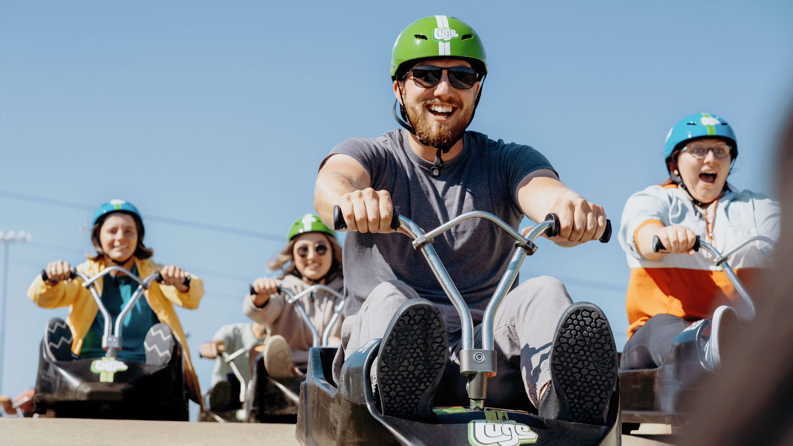 A man grins as he leads his friends down the tracks at Downhill Karting Calgary.