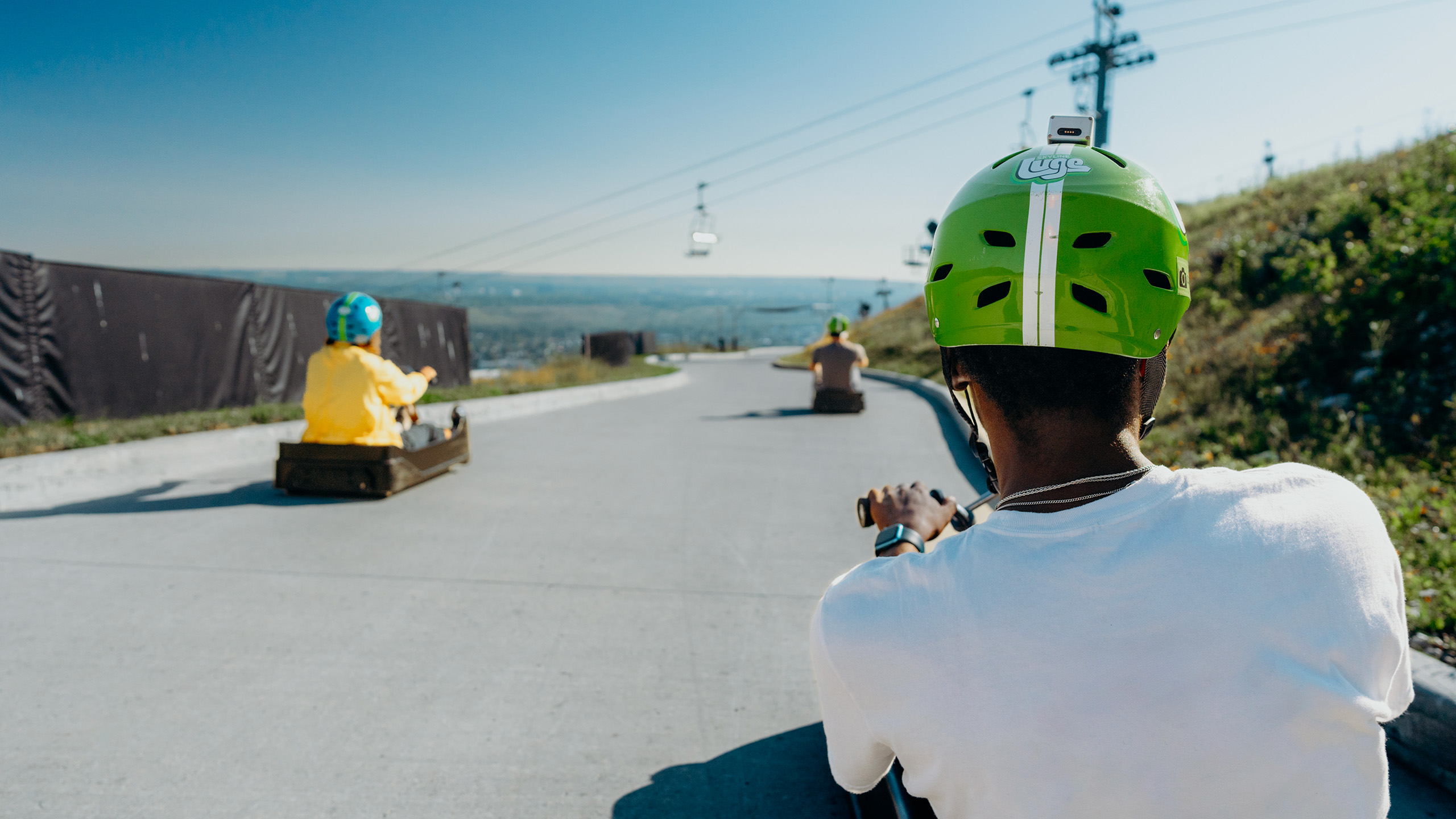A point of view shot of three people heading down the tracks at Downhill Karting Calgary.