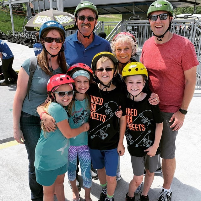A family group poses for a photo at the bottom of the chairlift at Downhill Karting Calgary.